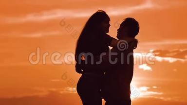 一对相爱的情侣在夕阳下拥抱<strong>剪影</strong>。 家庭爱情概念爱。 一对男女的爱情<strong>剪影</strong>
